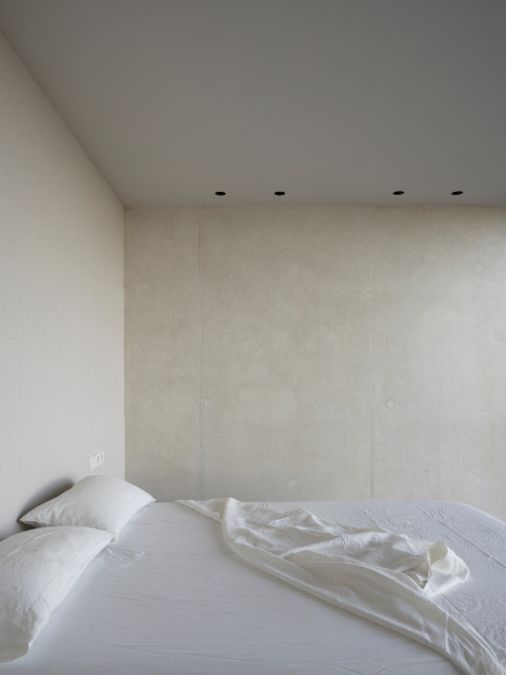 A bedroom with white walls and ceiling