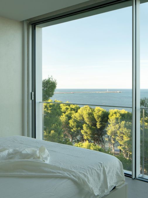 A bedroom with floor t ceiling glass window