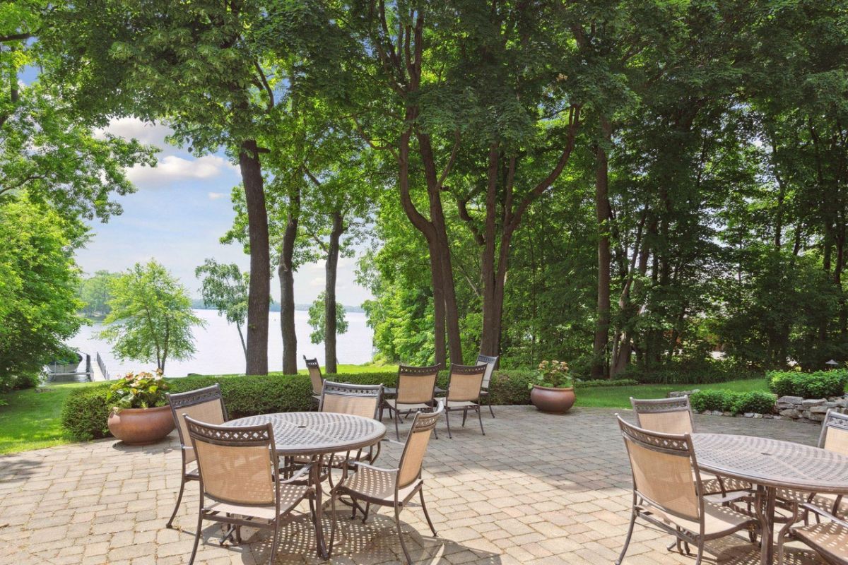 Patio with tables, chairs and a view of the lake.