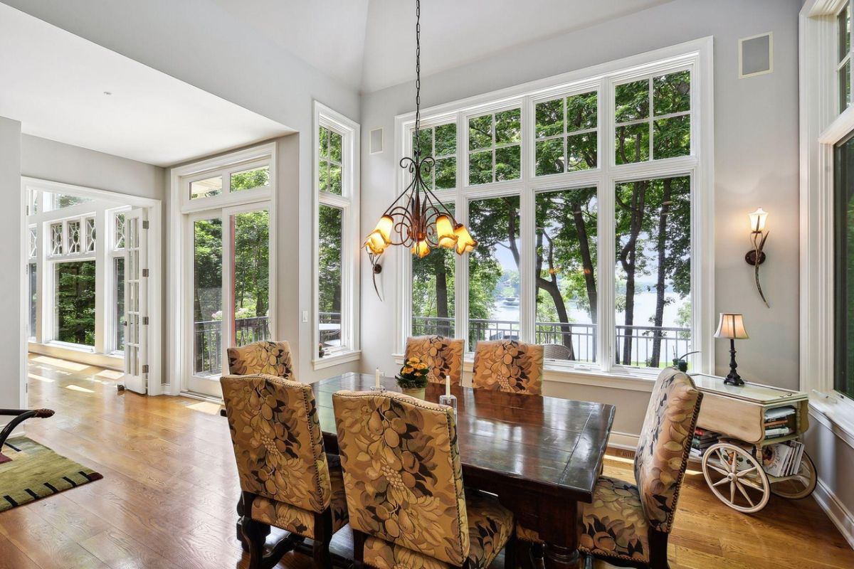 Breakfast area with wood flooring, glass windows, and a wooden table.