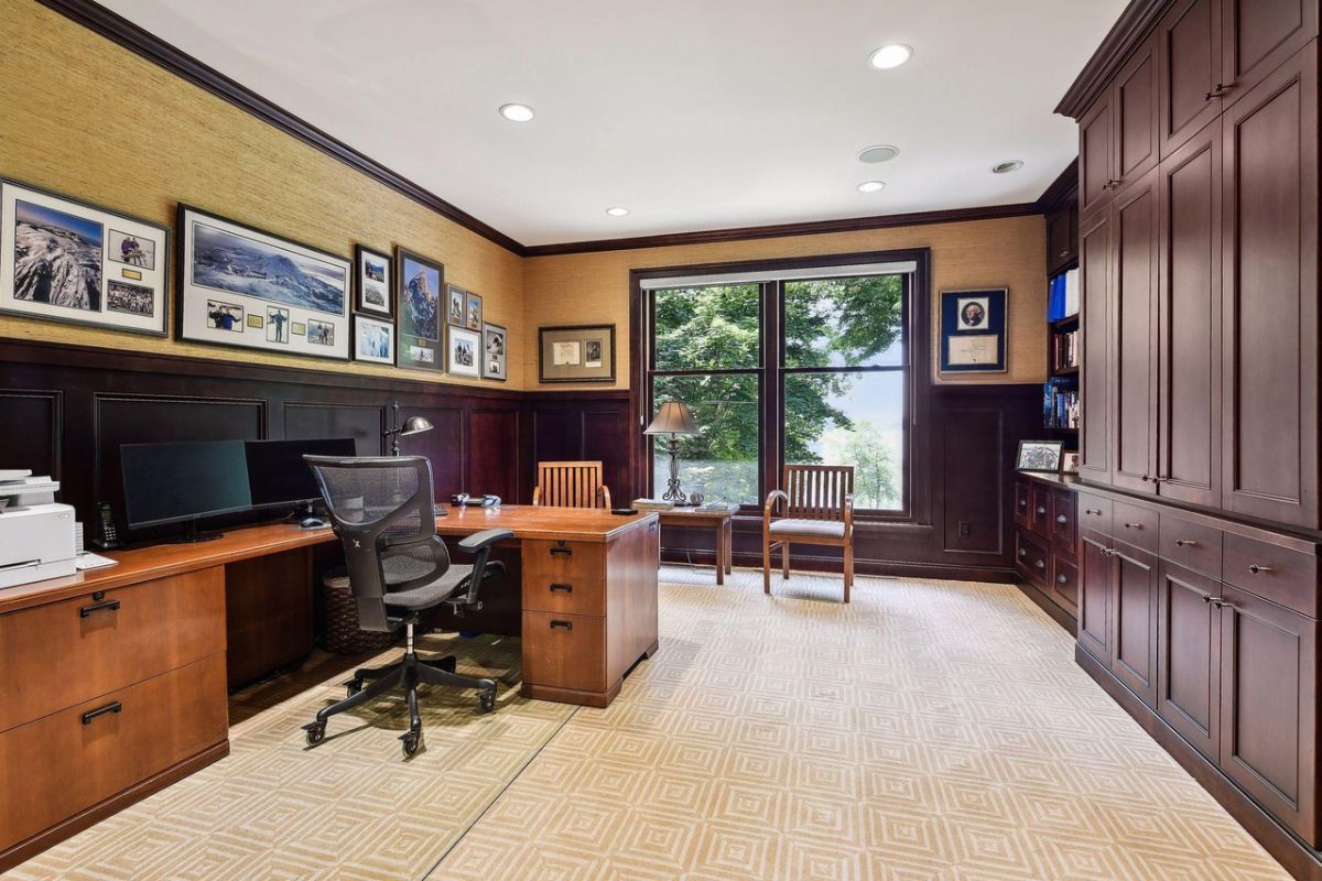 Home office with a desk, custom cabinetry, and a large glass windows