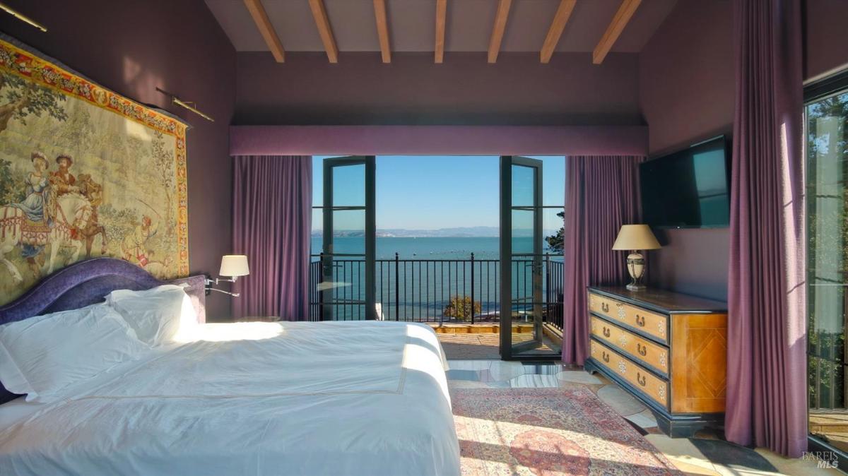 Bedroom with a large bed and a balcony.