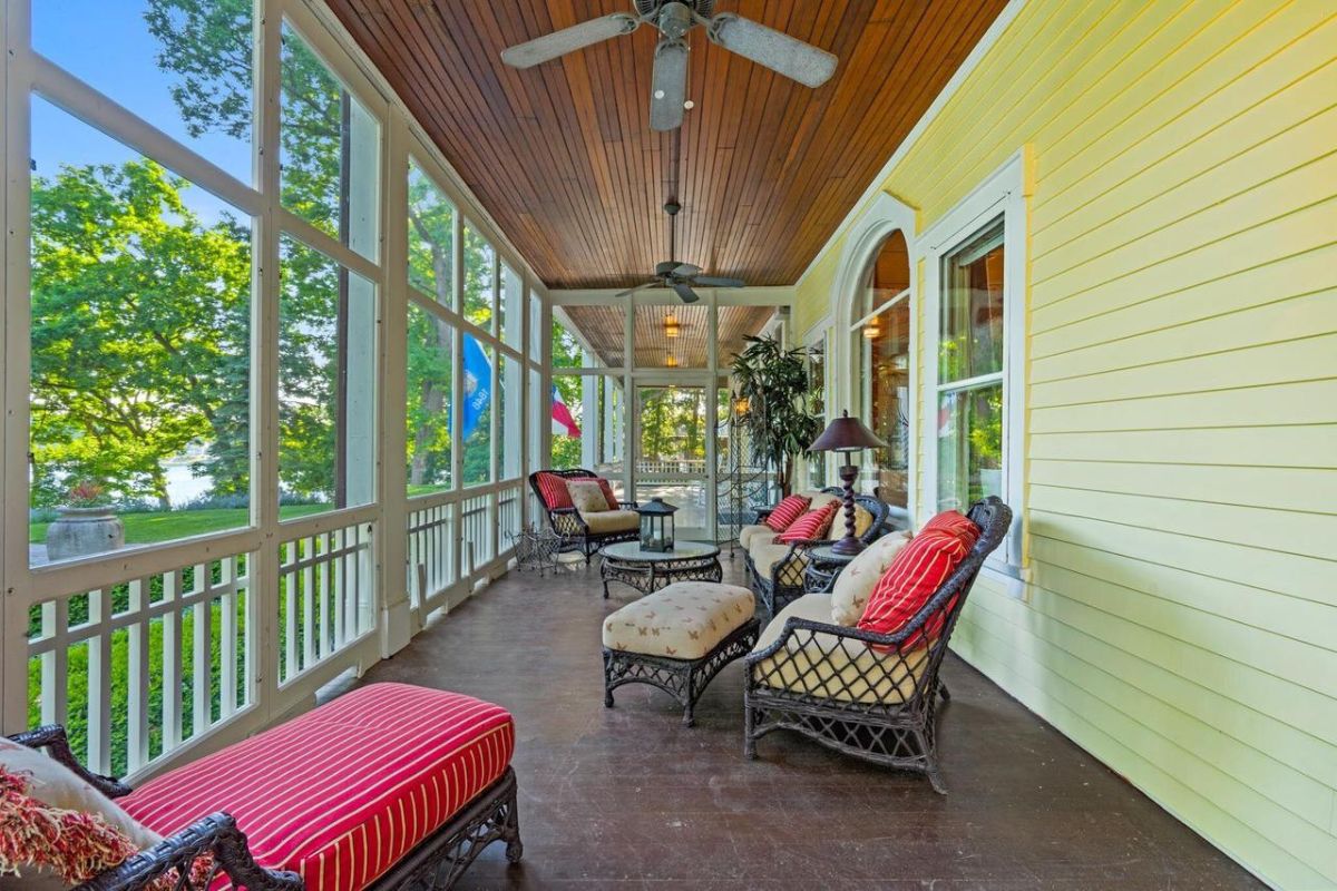 Porch with a ceiling fan, table, and chairs.