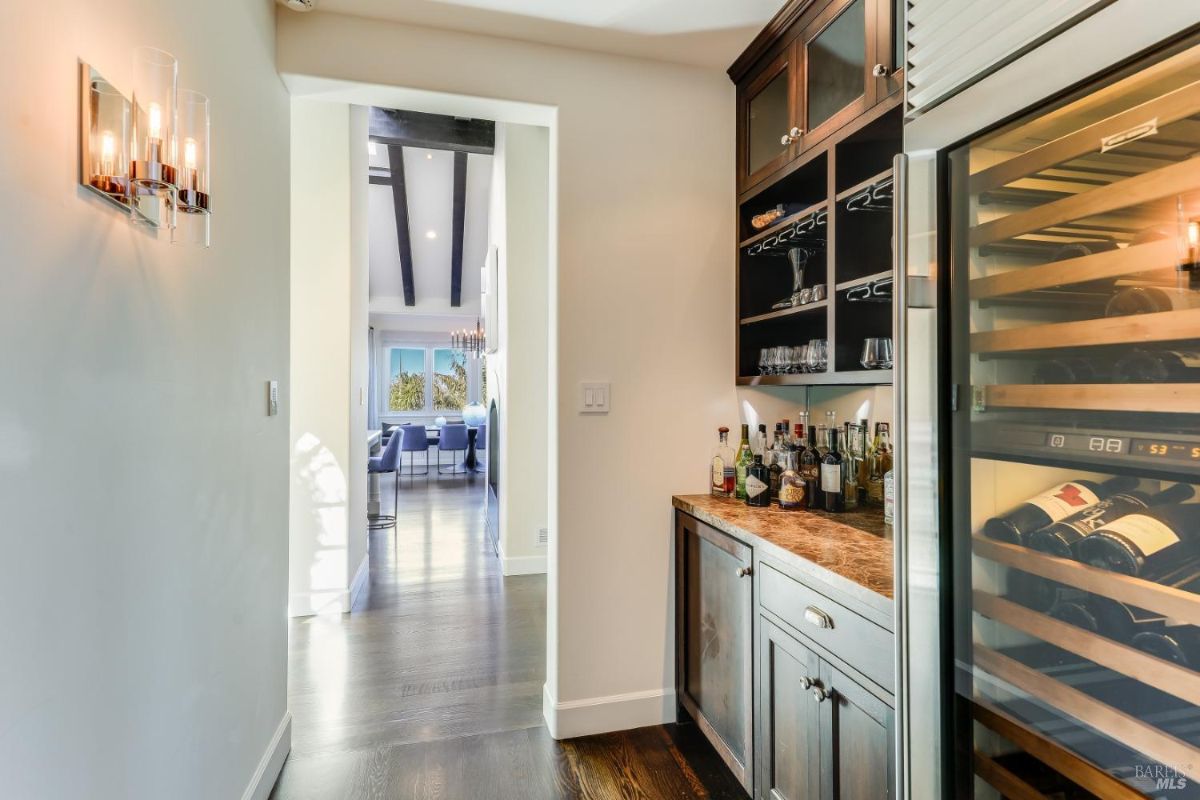 Wine cellar with wine refrigerator and a wine rack.