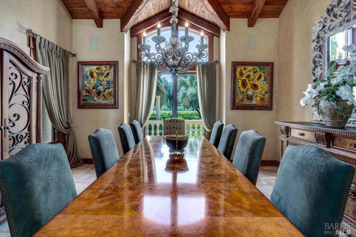 Dining room with a chandelier and glass windows.