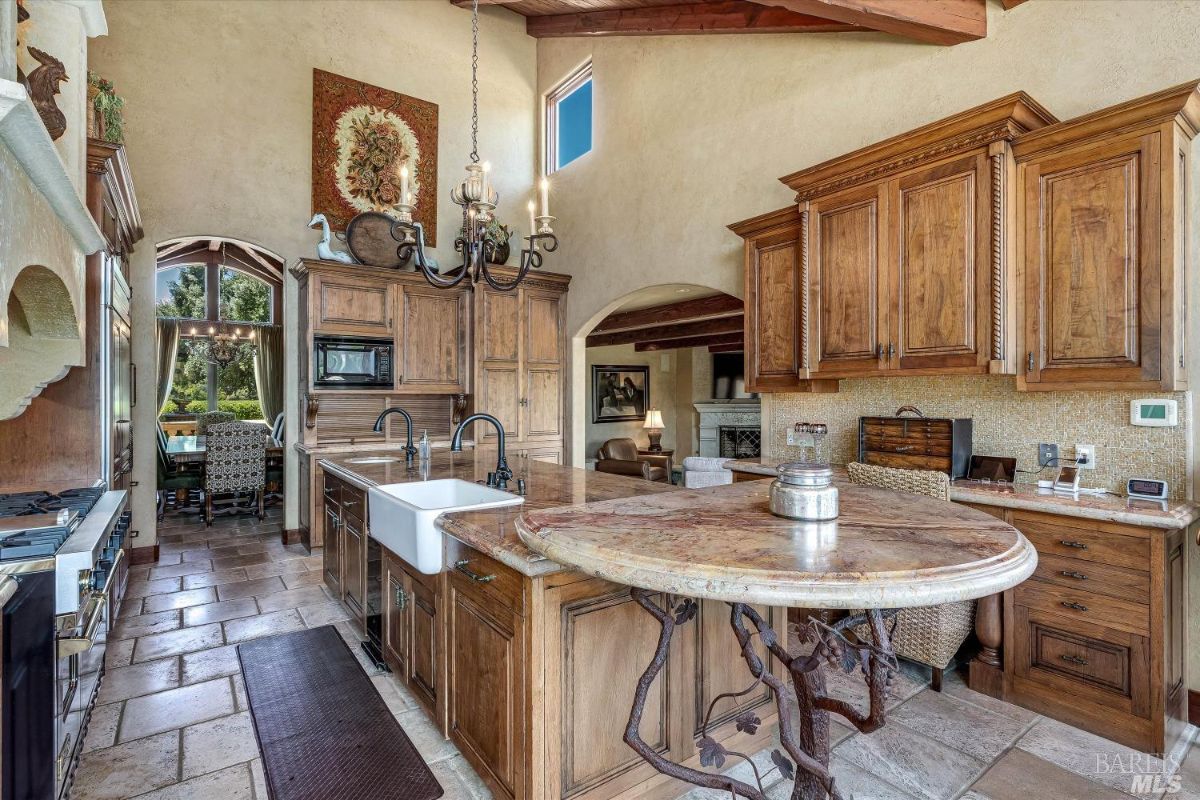 Kitchen with custom cabinets, a large island and a chandelier.