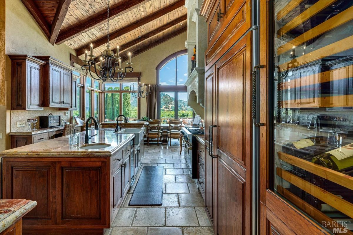 Kitchen with custom cabinets, a large island and a chandelier.