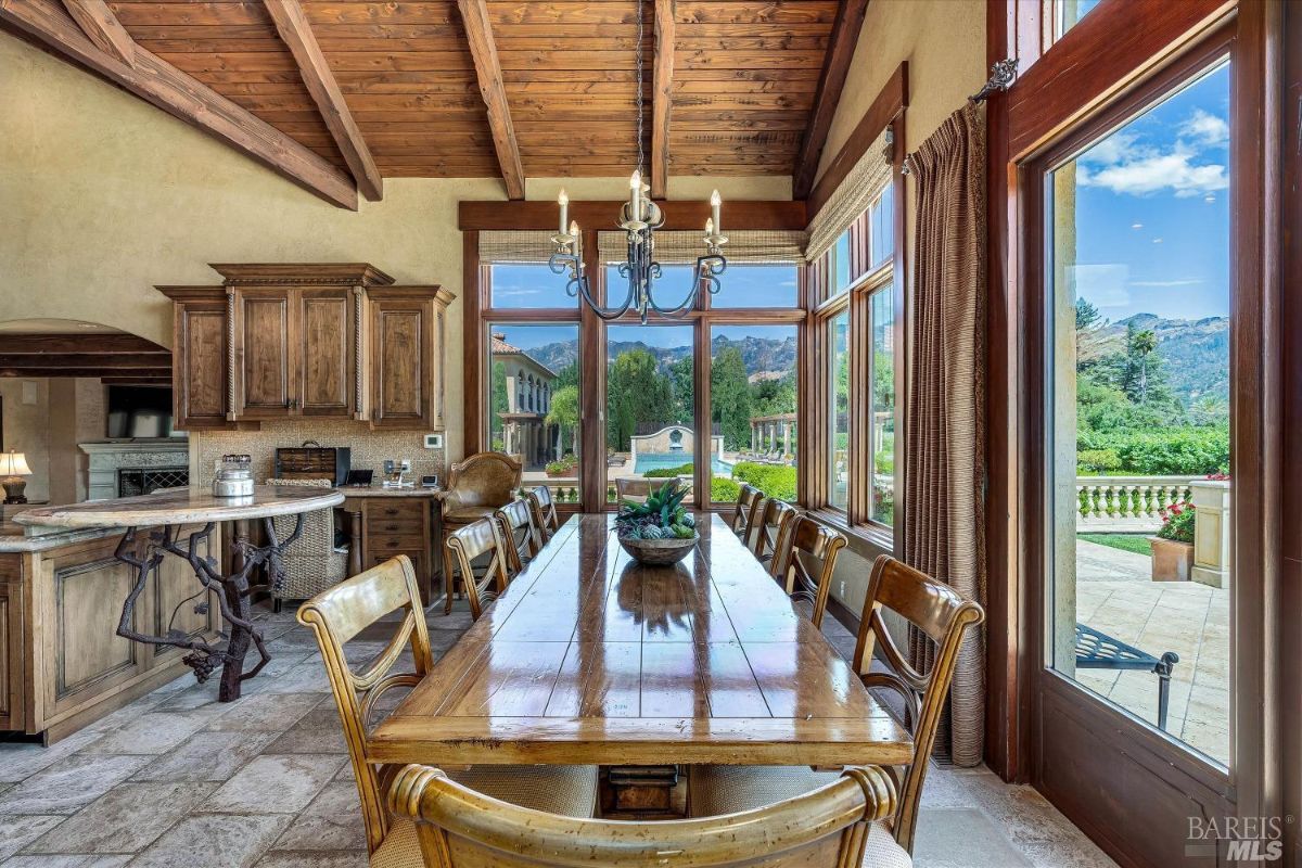 Dining room with a chandelier and glass windows.