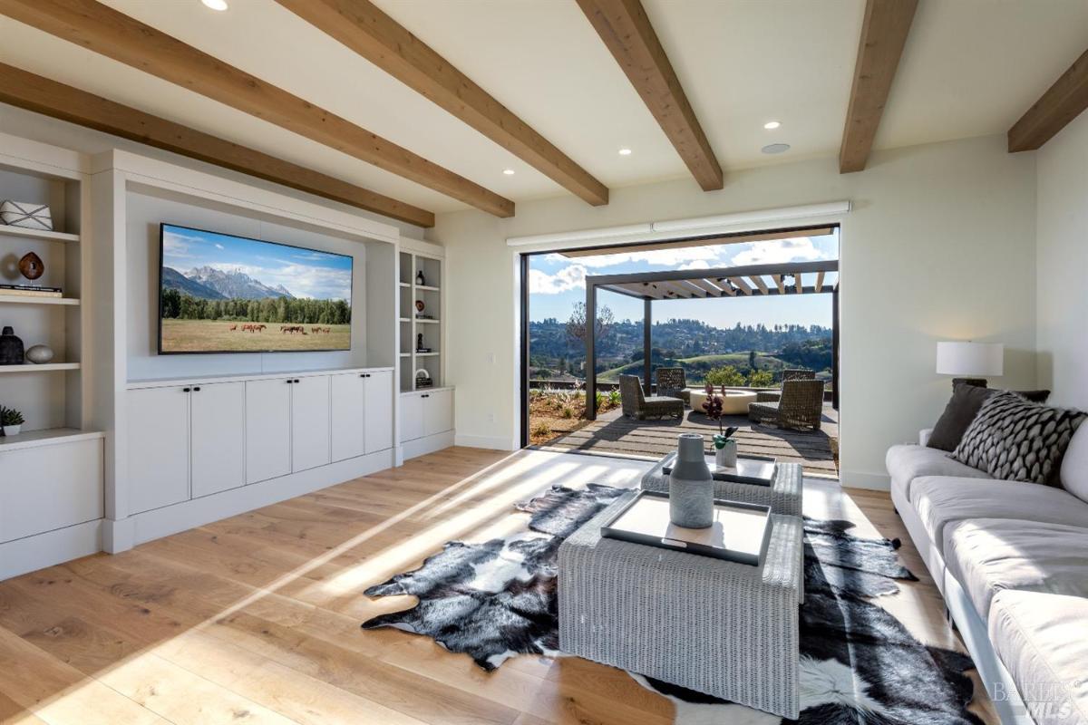 Family room with open bam ceiling and wood flooring.