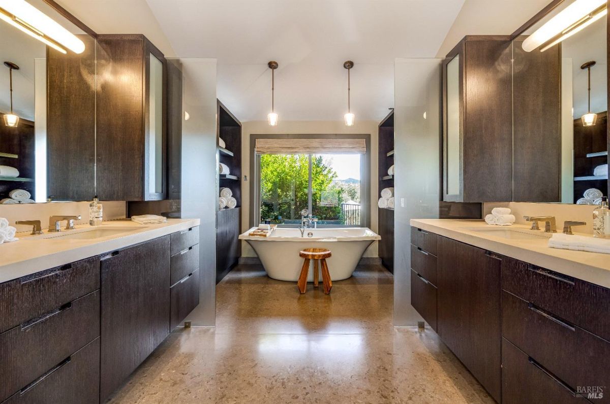 Bathroom with double sinks, custom lights and a soaking tub.