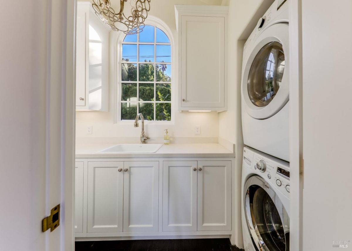 Laundry room with a sink, cabinets, washer and dryer.