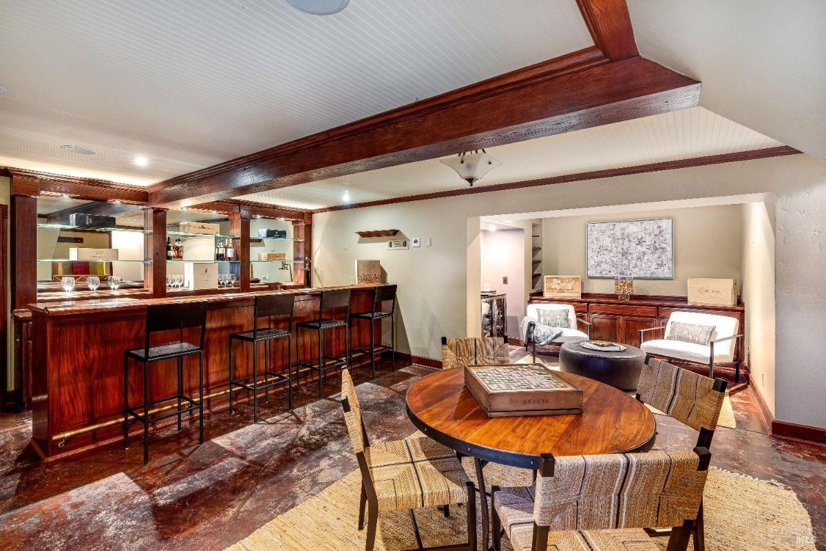 Recreation room with a bar, table and chairs.