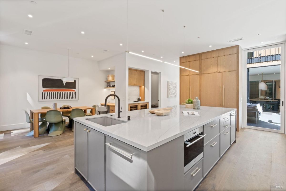 Kitchen with a large island, wood flooring and custom lights.