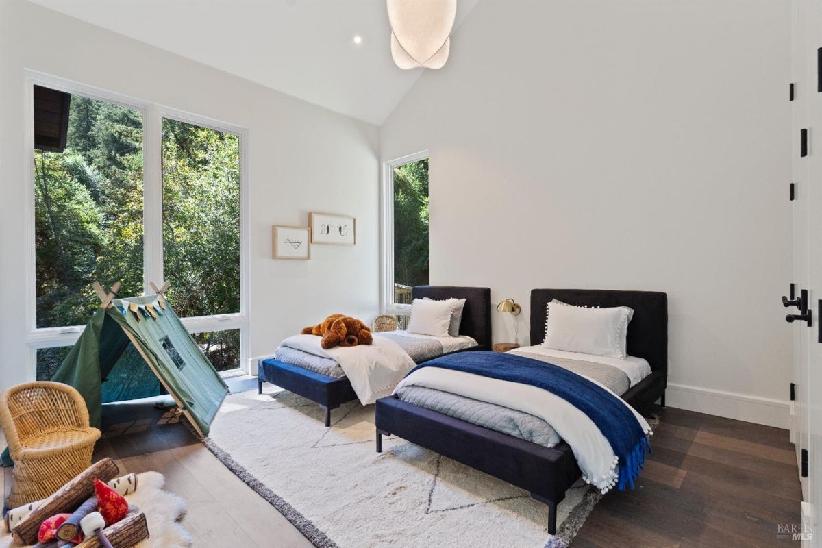 Bedroom with two beds and glass windows.