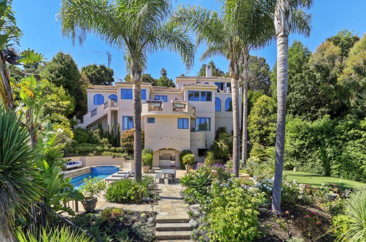 Rear view of the mansion with a huge backyard and a pool.