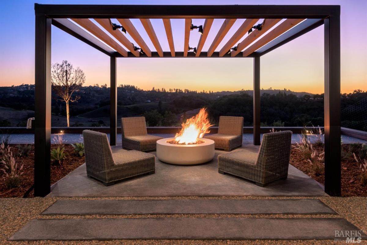 Firepit with chairs and pergola.