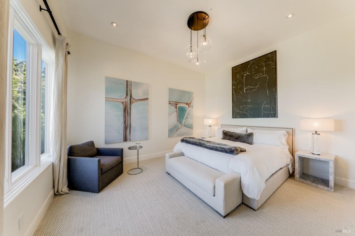 Bedroom with carpet flooring, custom lights and a couch.