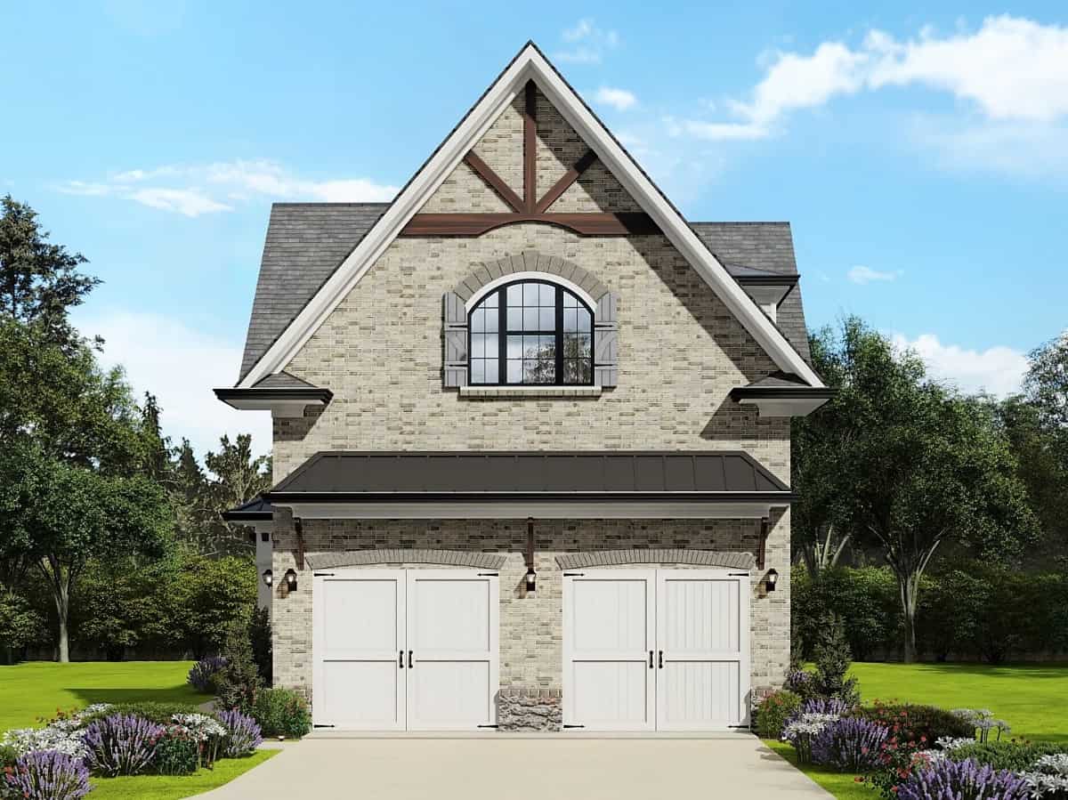 Front view of the carriage home with white garage doors and an arched shuttered window.