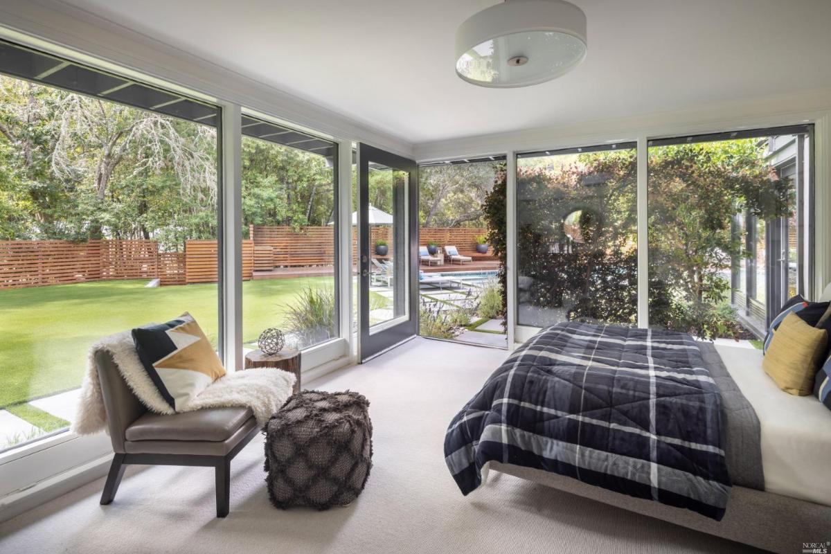 Bedroom with carpet flooring and large glass walls.