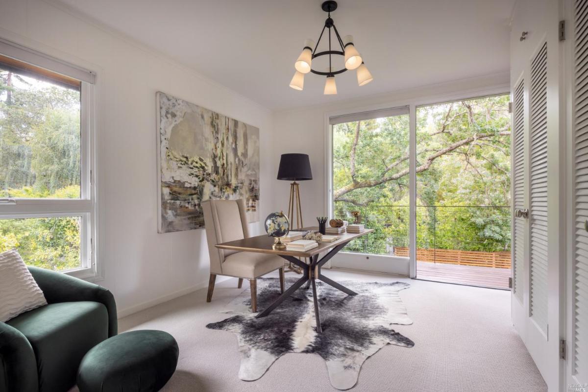 Home office with carpet flooring and glass doors.