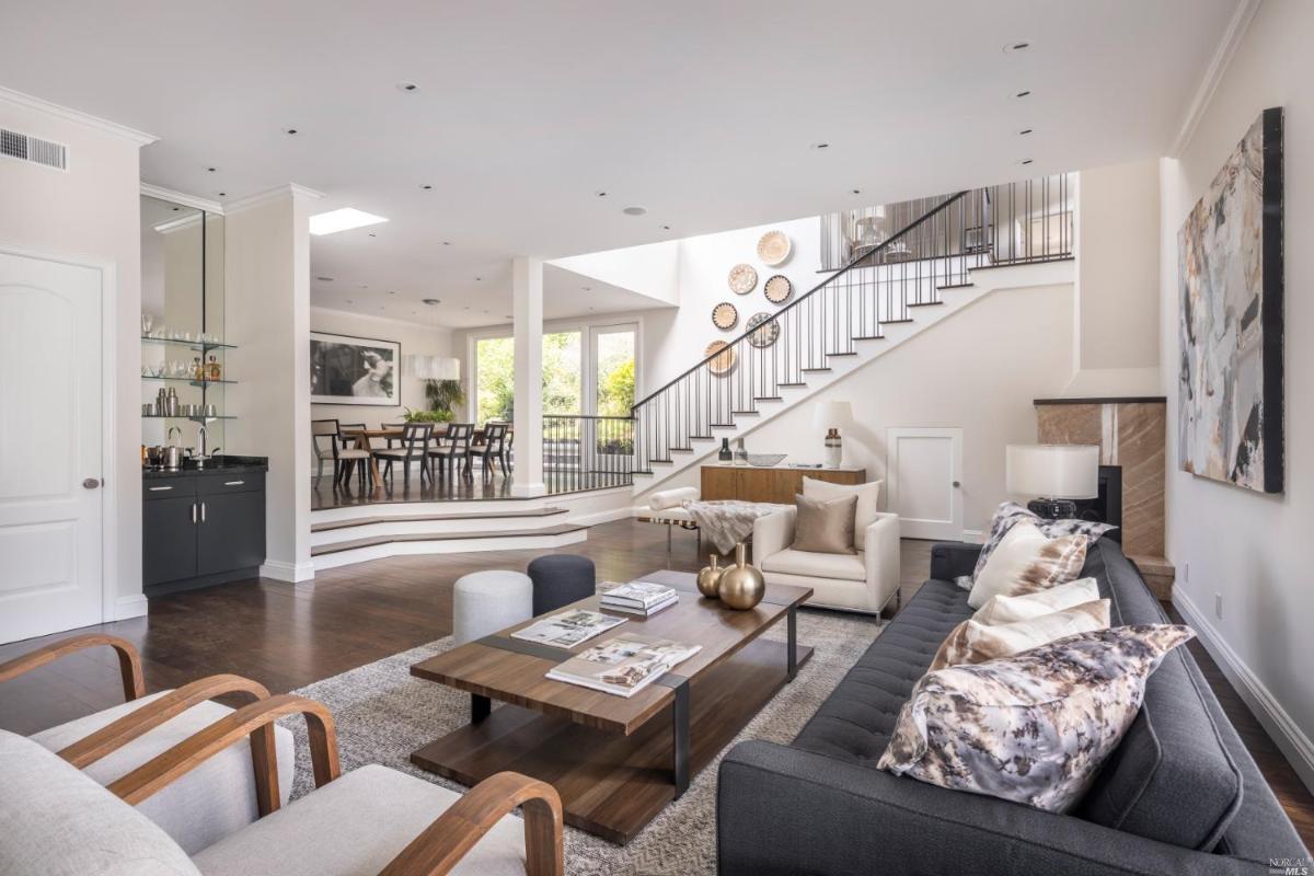 Living room with couches and wood flooring.