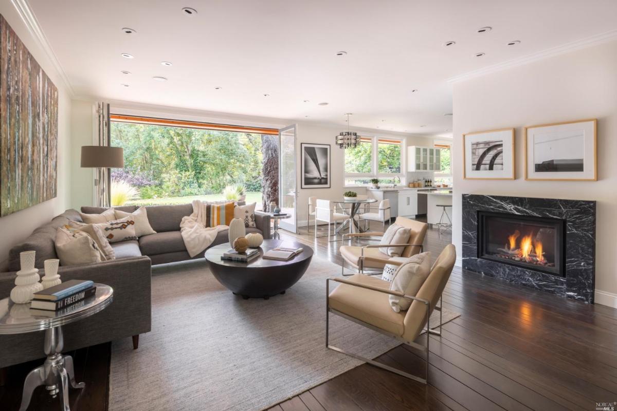 Living room with couches, fireplace and wood flooring.