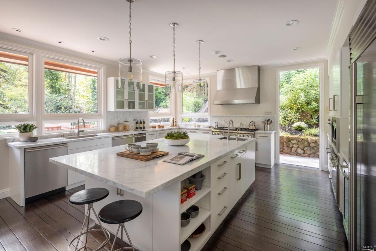 Kitchen with a large table, custom lights and glass windows.