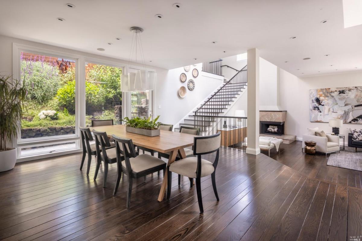 Dining room with wood flooring and custom lights.