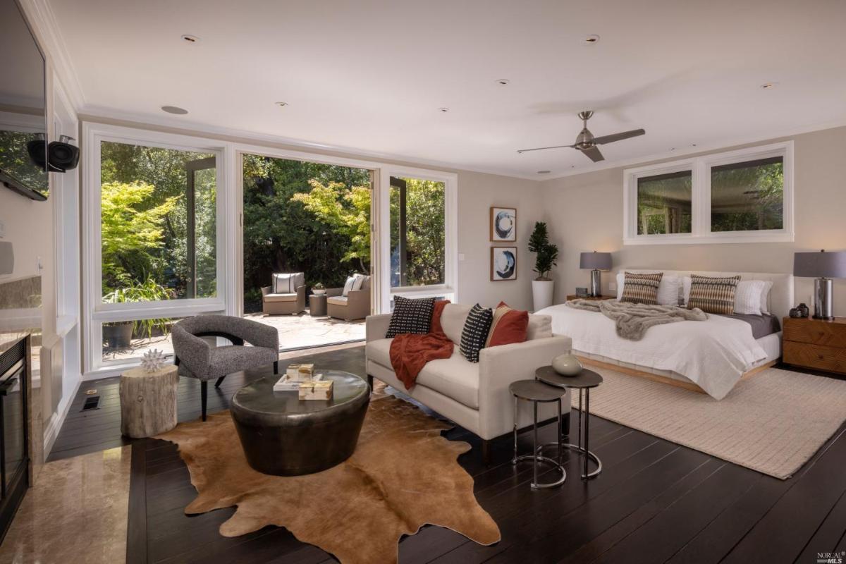 Bedroom with a large bed, living space and wood flooring.