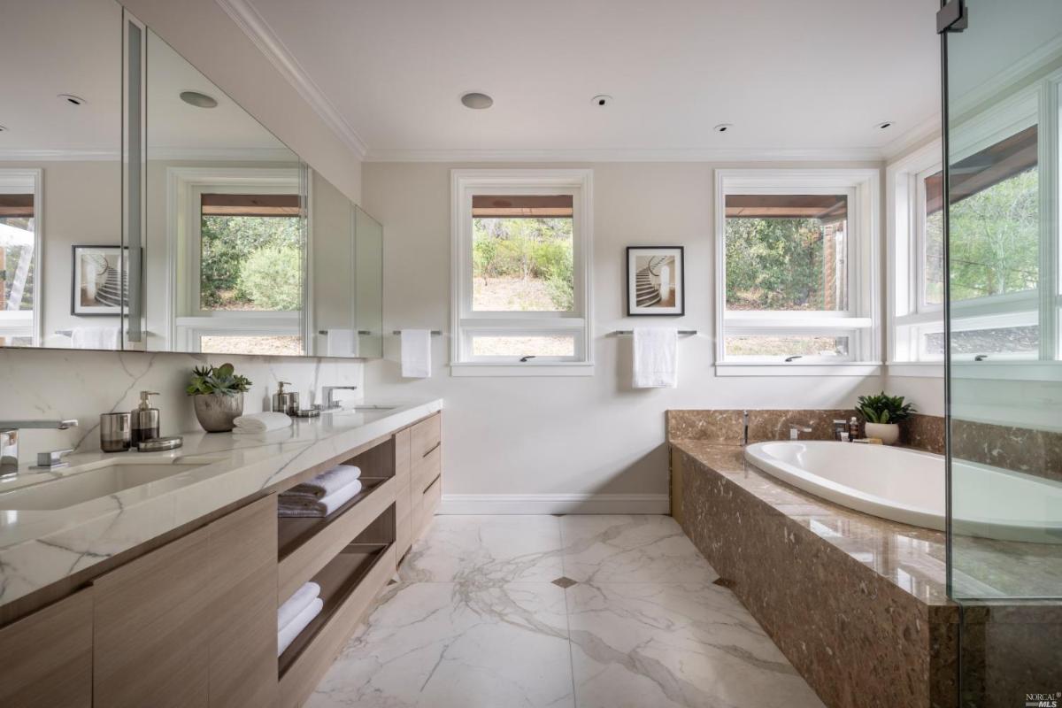 Bathroom with soaking tub and sinks.