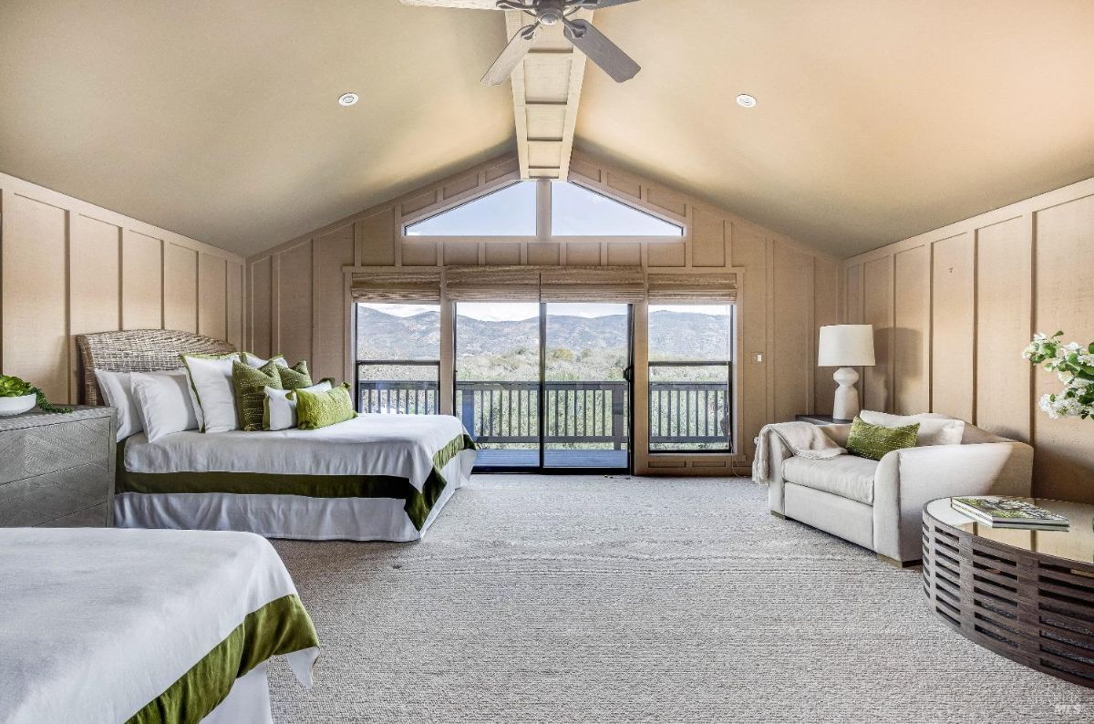 Bedroom with a ceiling fan, two beds and a couch.