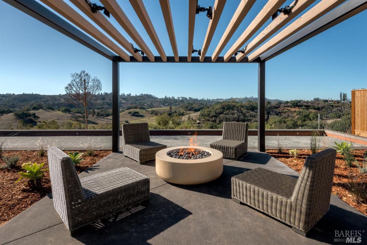 Firepit with chairs and pergola.