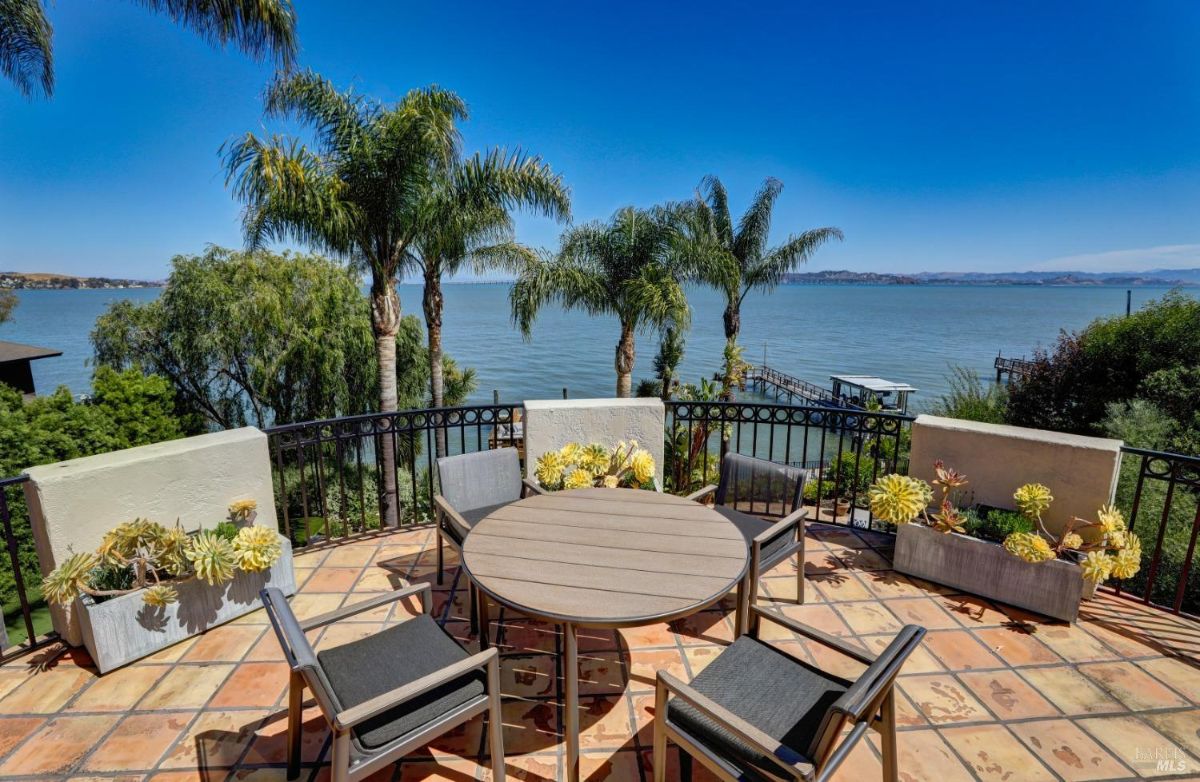 Patio with a table and chairs overlooking the bay.