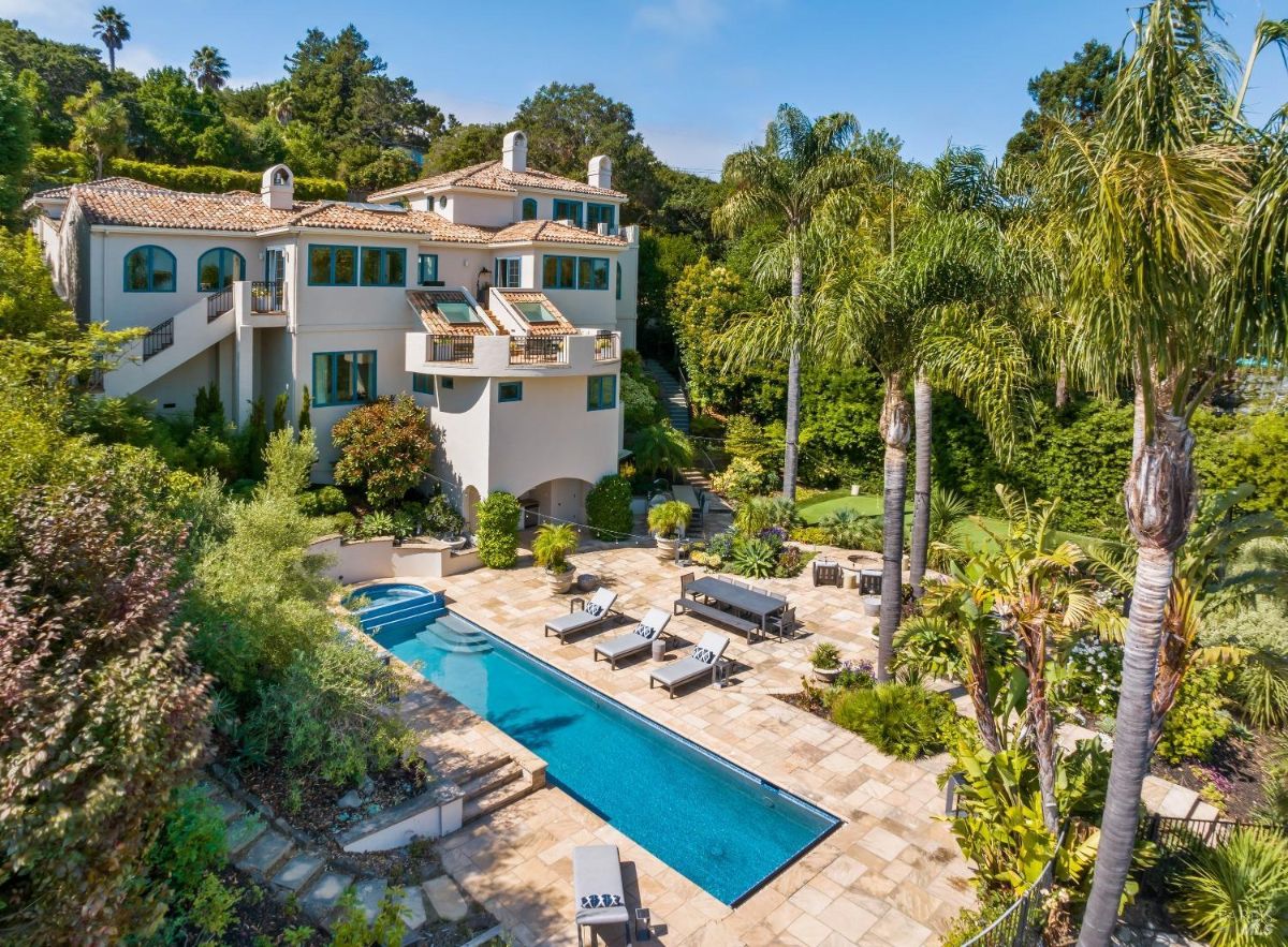 Aerial view of the mansion with a pool, patio, and a golf course.