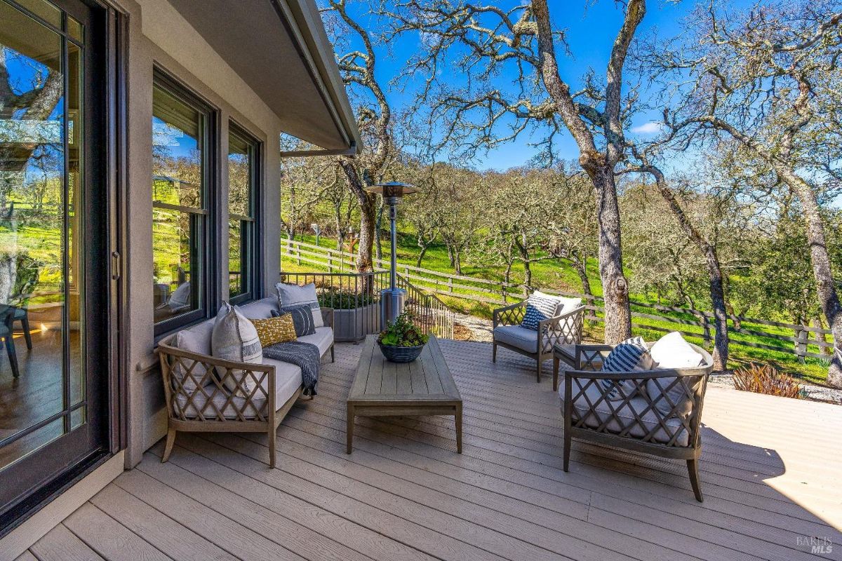 Patio on a wooden deck with a table and chairs.