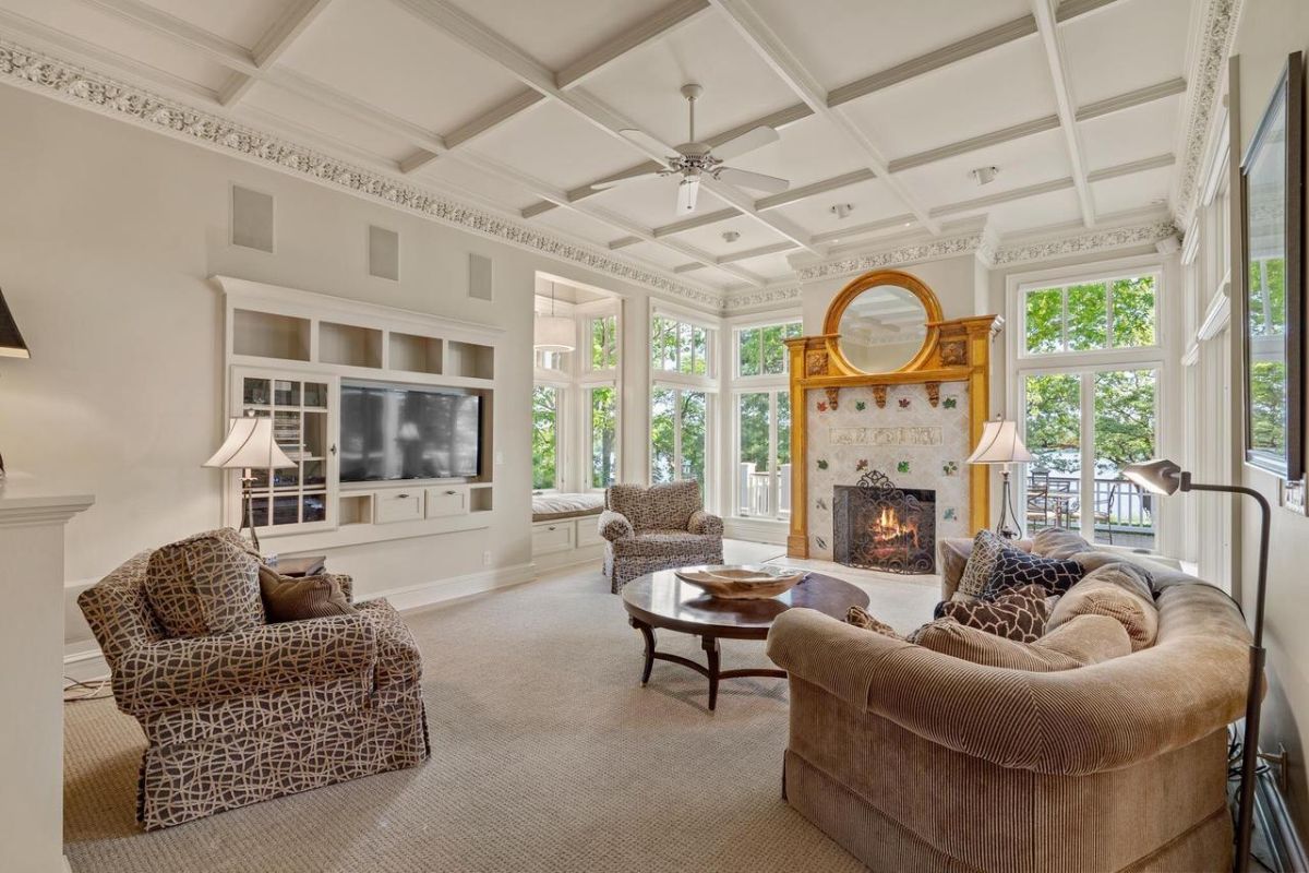 Living room with couches, carpet flooring, a TV, and a fireplace.