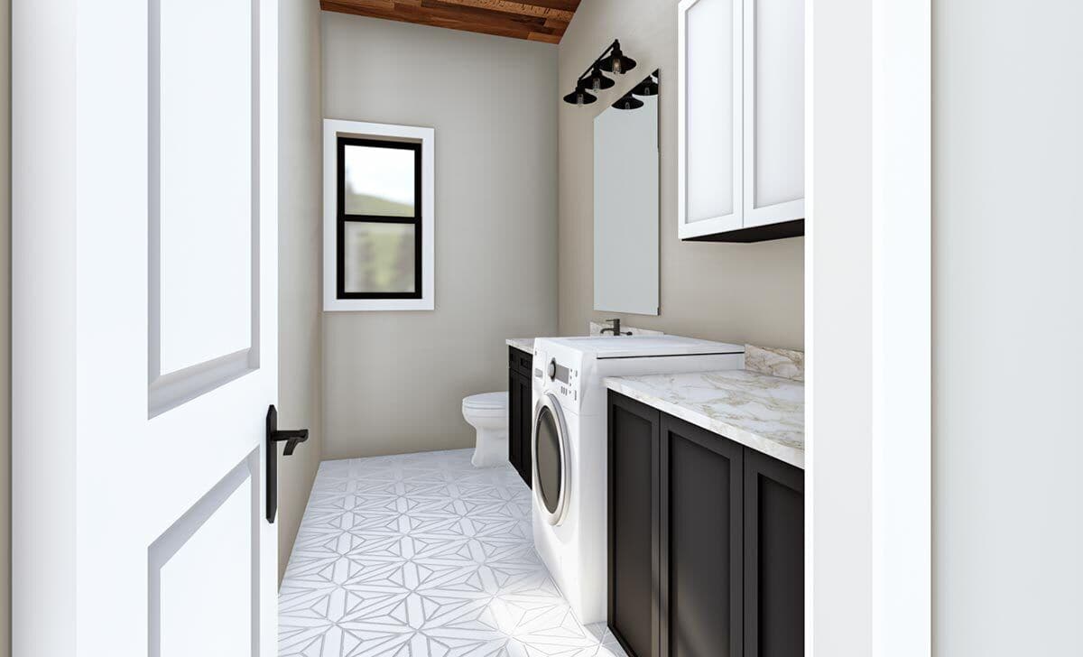 Combined powder and laundry room with decorative-tiled flooring, marble countertops, and contrasting cabinets.