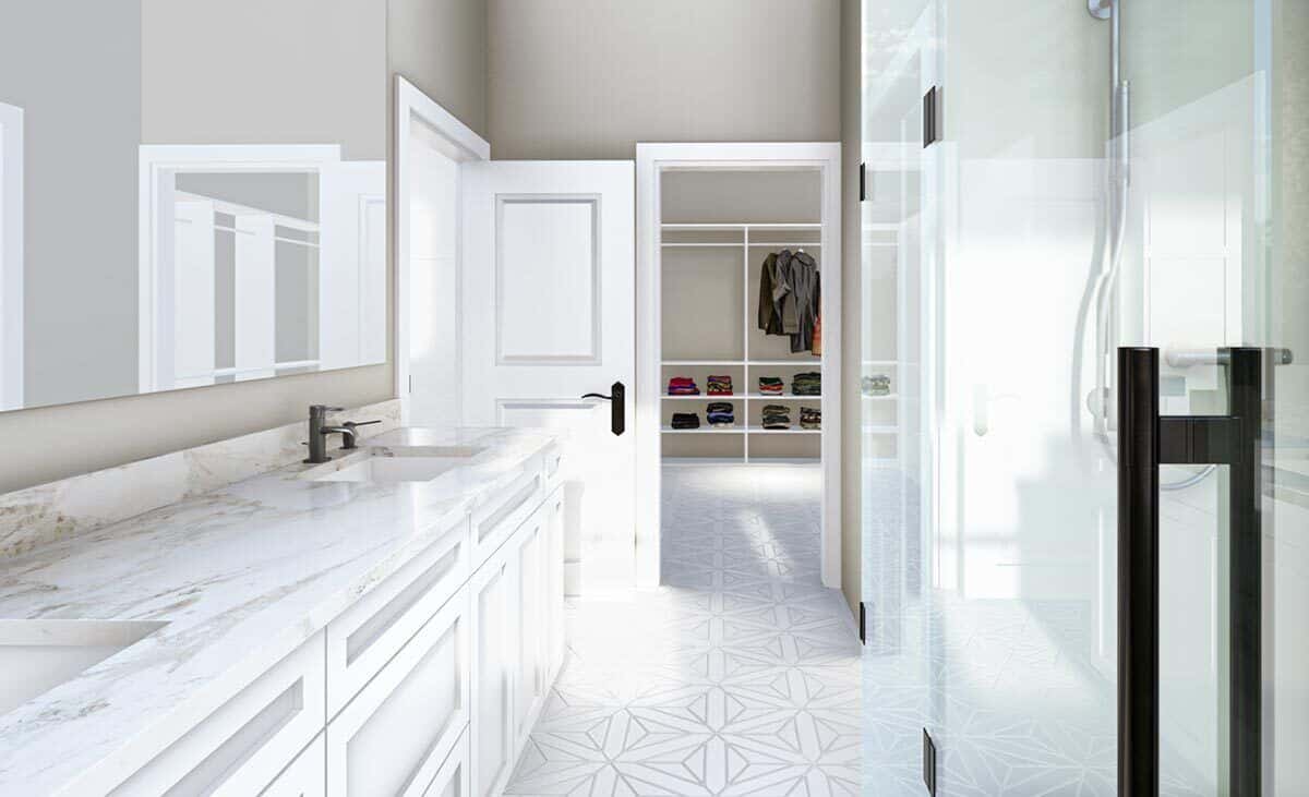 Primary bathroom with a dual sink vanity, a tiled shower, and a walk-in closet.