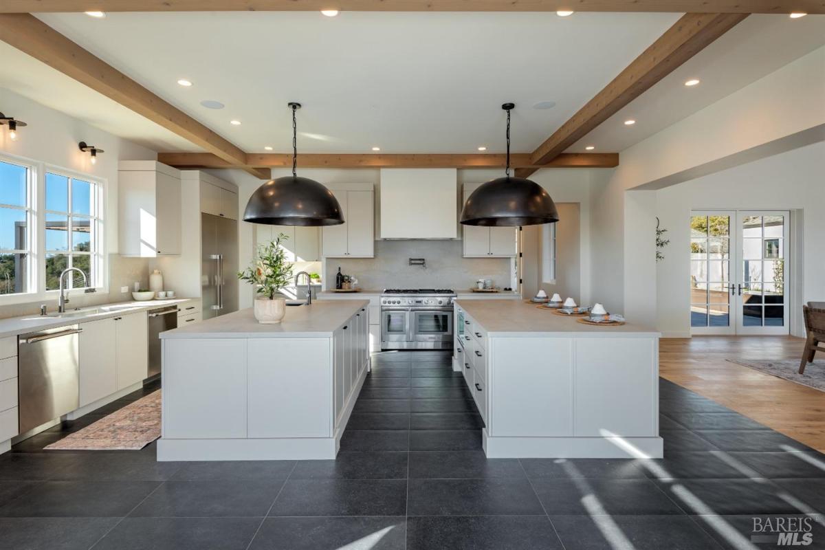 Kitchen with open beam ceiling and custom lights.