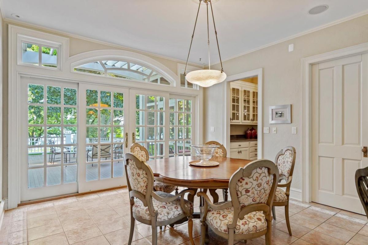 Breakfast area with tile flooring and glass windows leading to the balcony.