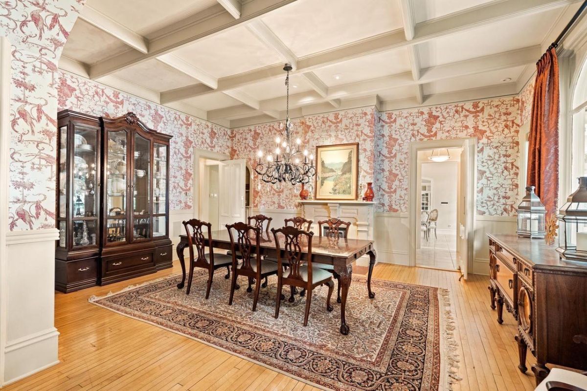 Dining room with a chandelier, wood flooring, a large rug, and a wooden table.