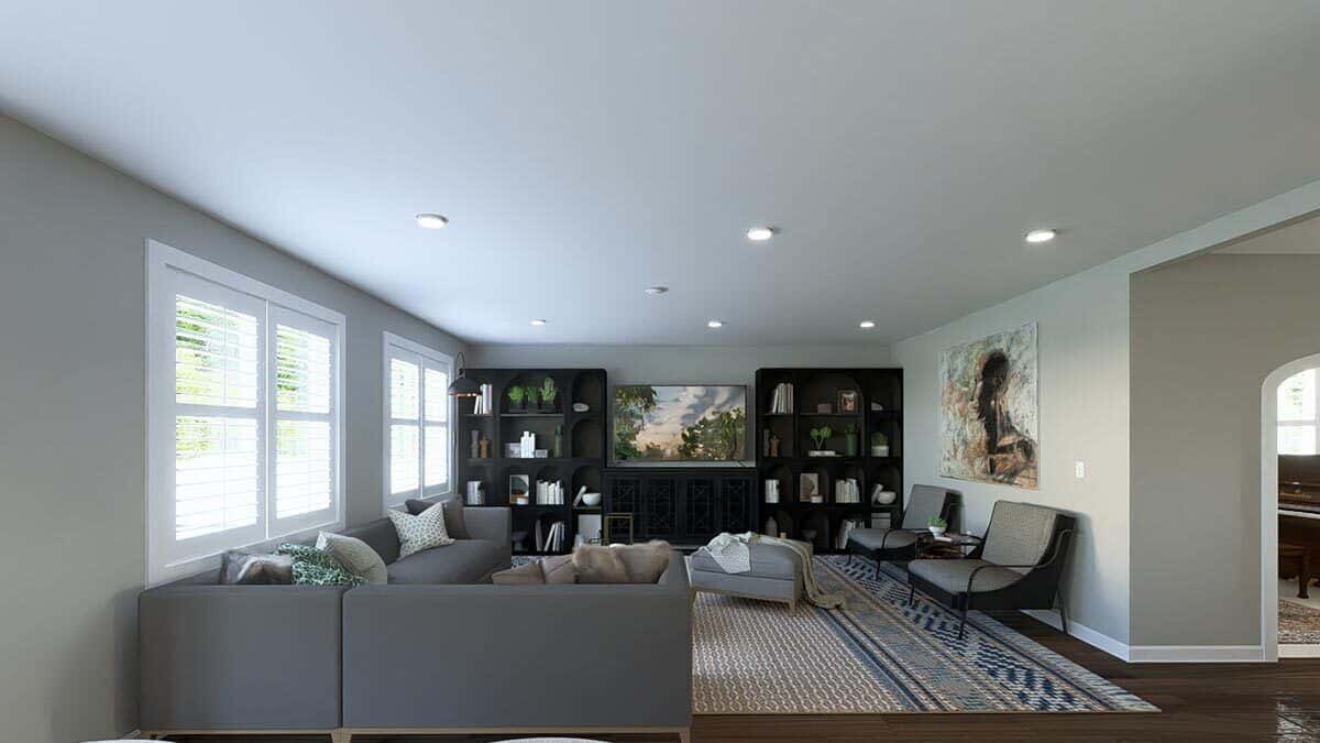 Living room with an L-shaped sofa, cushioned chairs, and a TV flanked by dark wood cabinets.