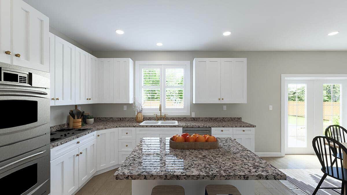 Kitchen with white cabinetry, double wall ovens, a center island, and double sinks under the louvered windows.