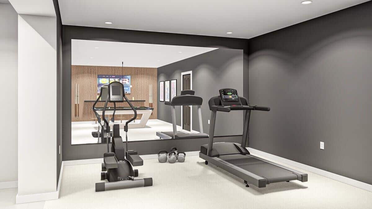 Gym with black walls, a massive mirror, and a carpeted floor.