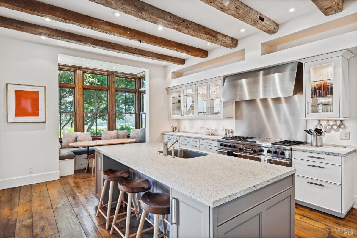 Kitchen with open beam ceiling and wood flooring.