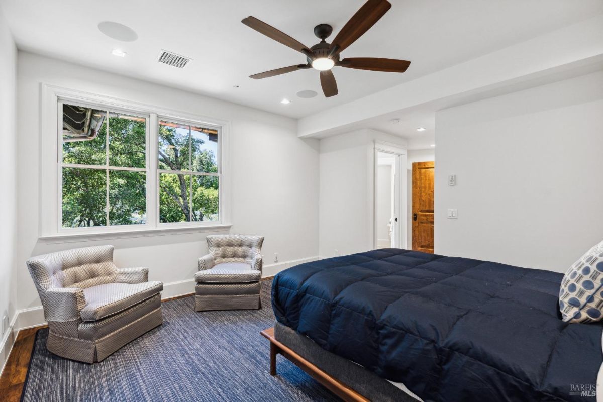 Bedroom with a large bed and glass windows.