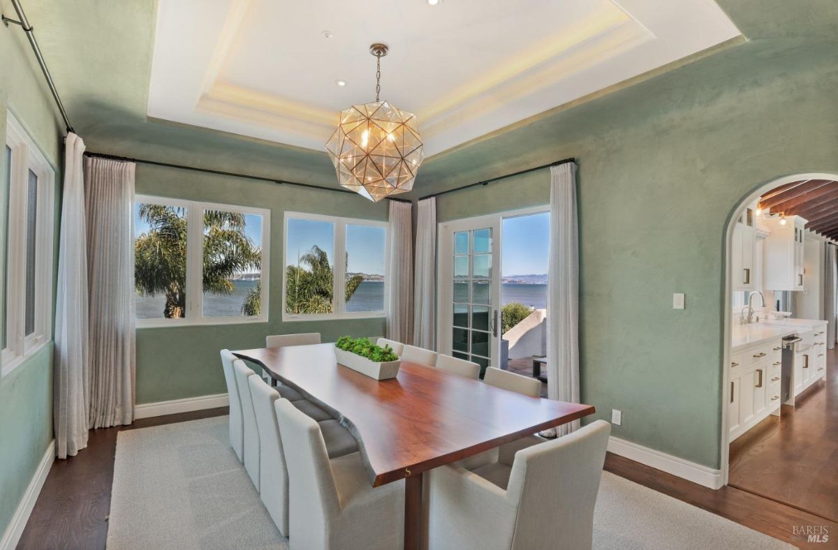 Dining room with a chandelier, glass doors, glass windows and a view of the bay.