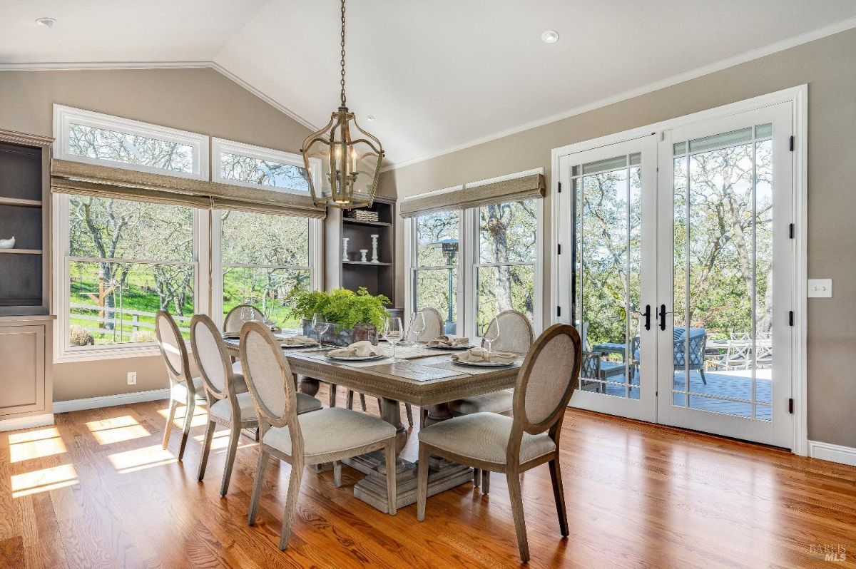 Dining room with a chandelier, French doors, and glass windows.