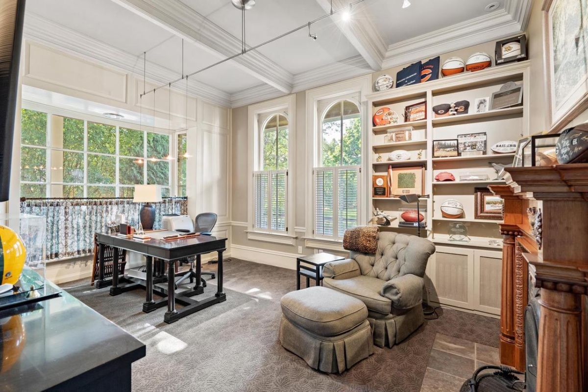 Home office with a desk, a couch, and glass windows.