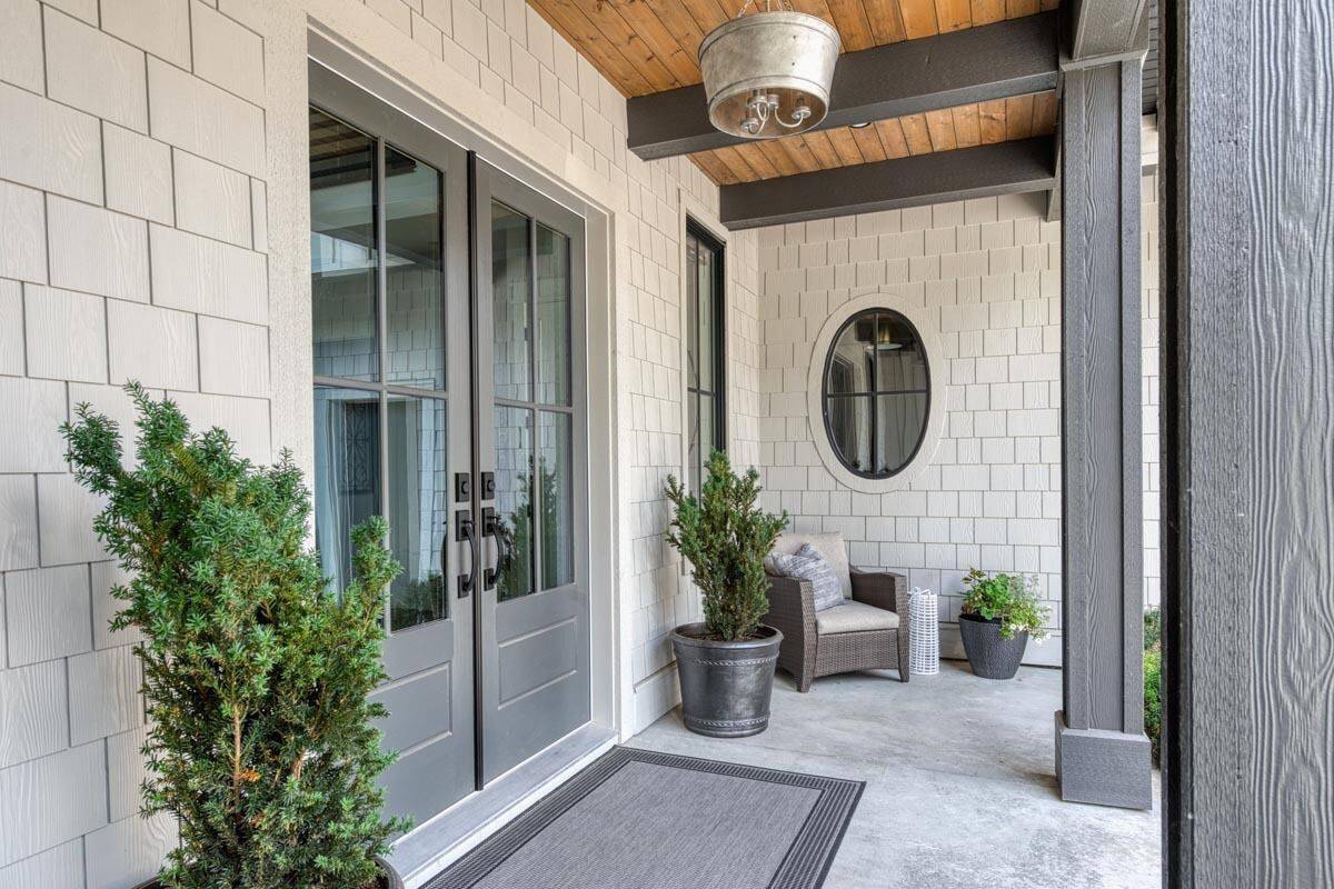 Entry porch with a French front door and a wood-paneled ceiling accentuated with exposed beams.